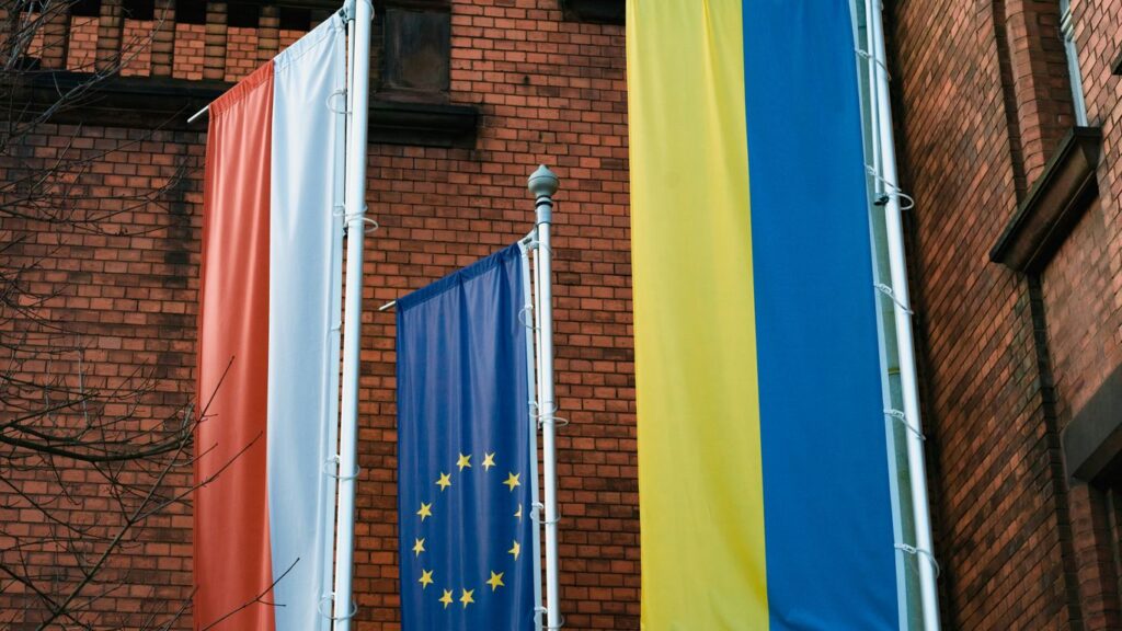 a brick building with three flags hanging from it's sides