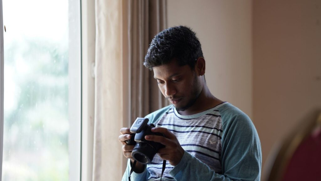 man in gray crew neck t-shirt holding black dslr camera