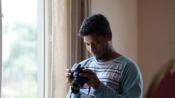 man in gray crew neck t-shirt holding black dslr camera