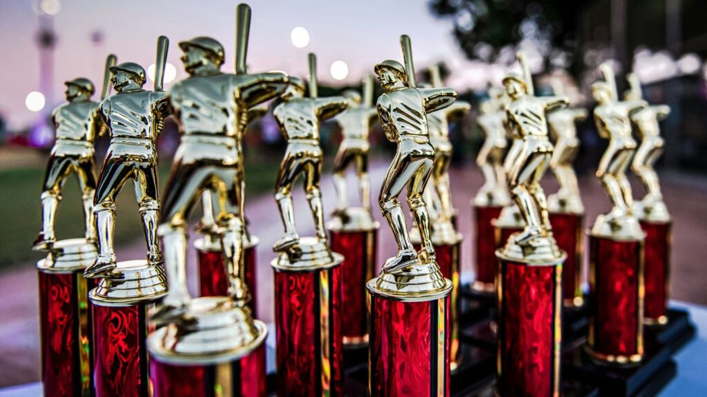 Collection of baseball trophies displayed outdoors at dusk.