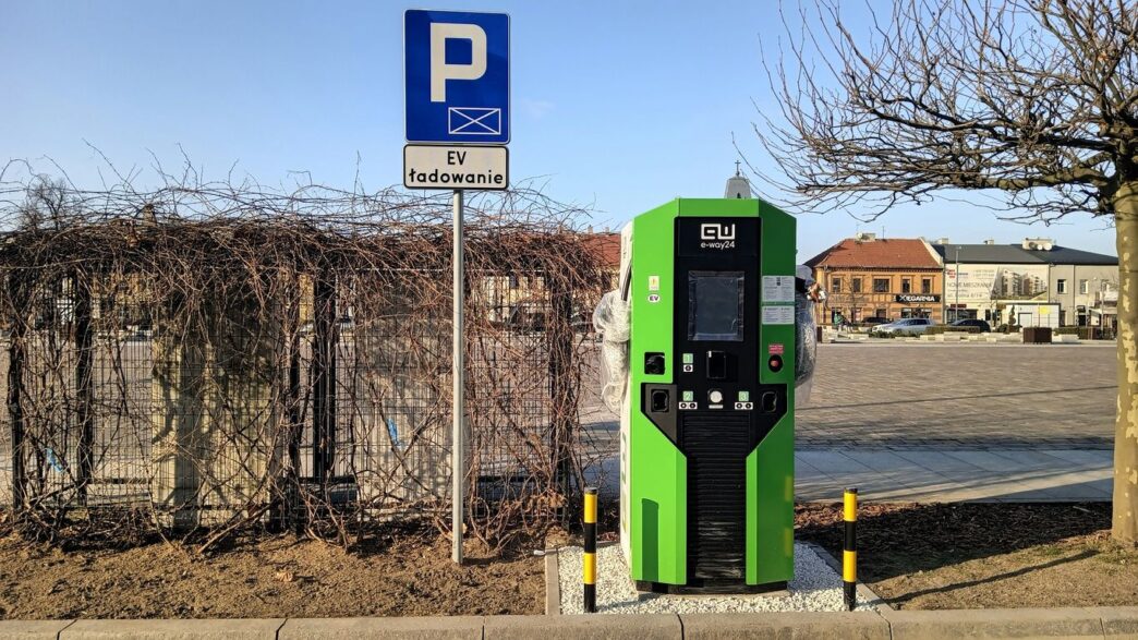 a green parking meter next to a parking sign