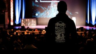 man in black crew neck shirt standing on stage