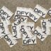 a pile of black and white stickers sitting on top of a floor