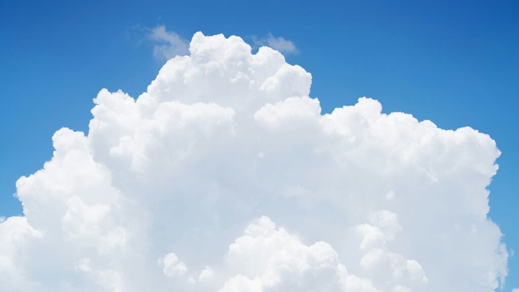 a large cloud in the sky with a blue sky background