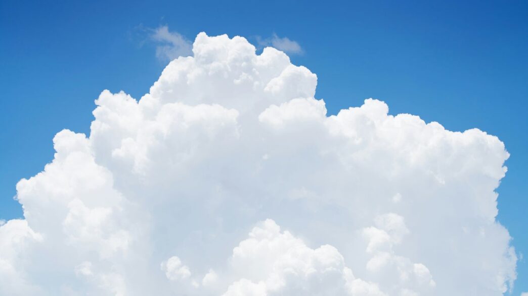 a large cloud in the sky with a blue sky background