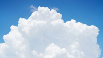 a large cloud in the sky with a blue sky background