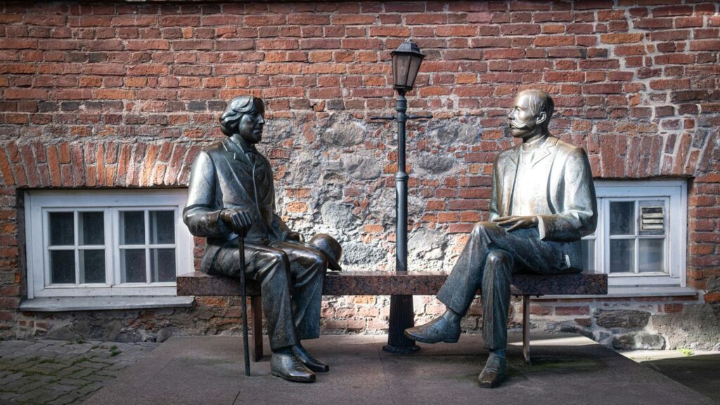 Two bronze statues sit on a bench