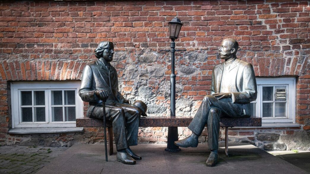 Two bronze statues sit on a bench
