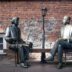 Two bronze statues sit on a bench