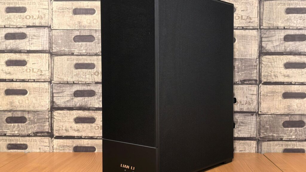 A black computer tower case stands on a wooden surface.