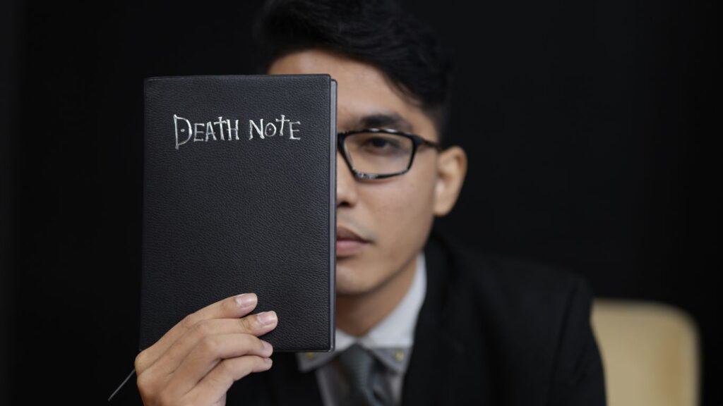 man in black suit holding black book