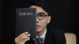 man in black suit holding black book