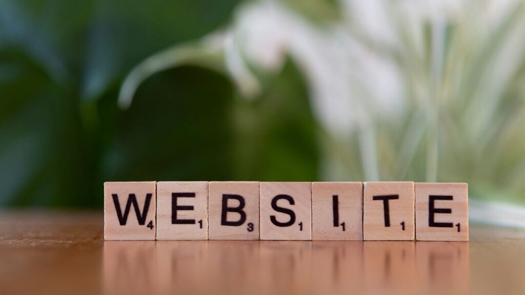 A wooden block spelling the word website on a table