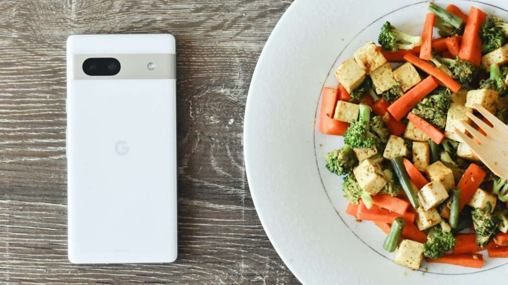 a plate of food with a cell phone next to it