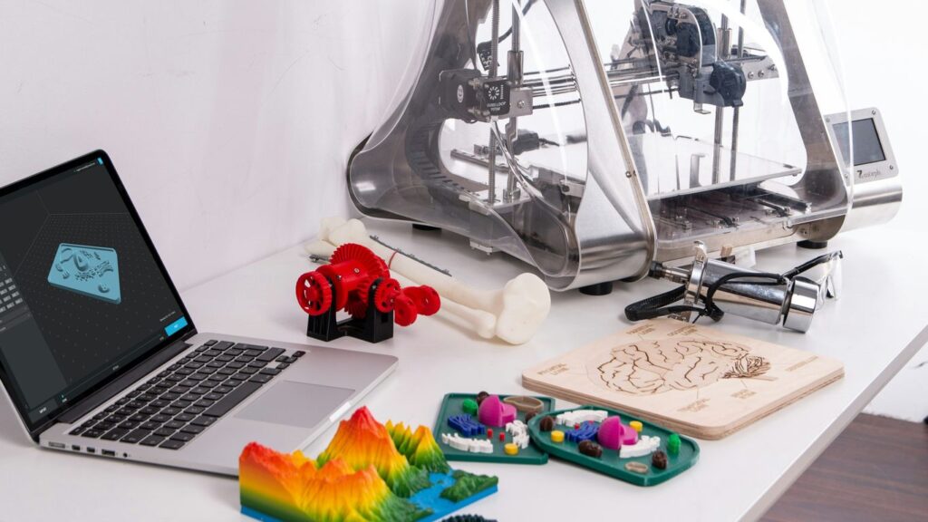 MacBook Pro beside 3D printer