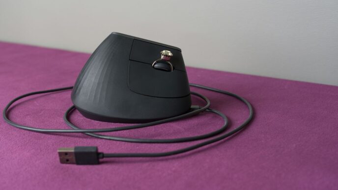 An ergonomic computer mouse rests on a purple surface.