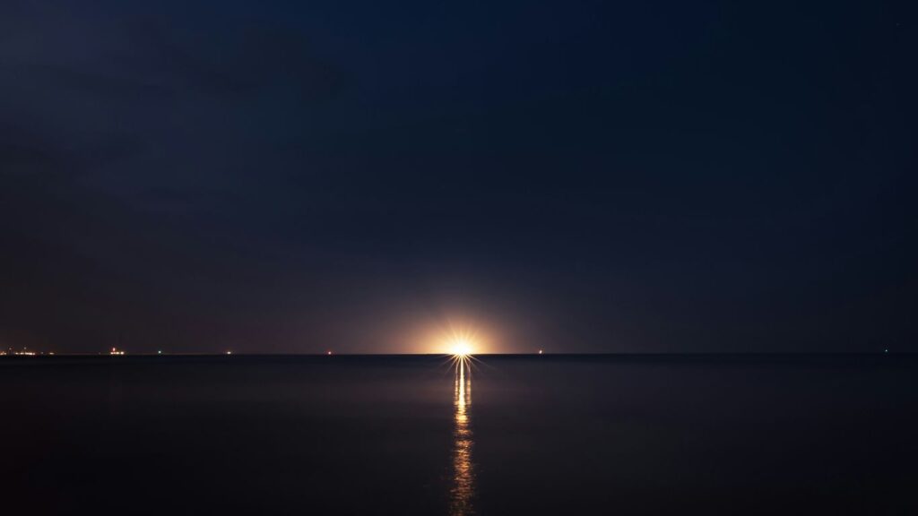 light post on the sea during night time
