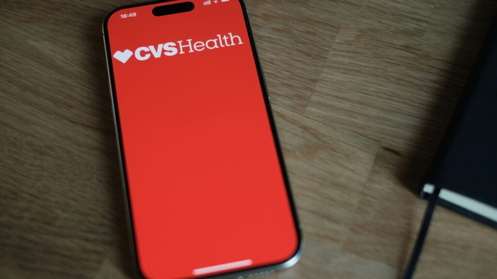 A red cell phone sitting on top of a wooden table