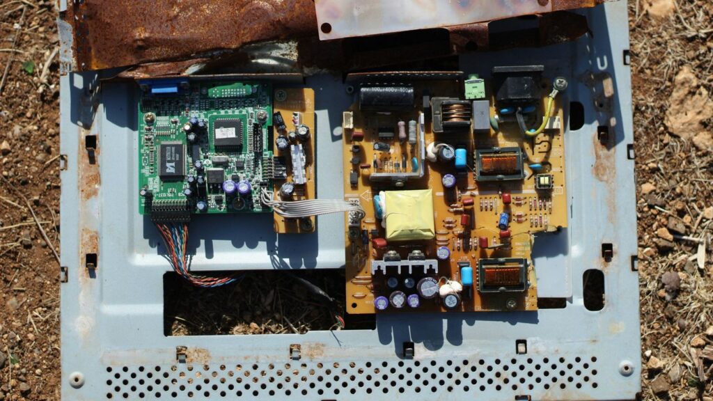 Discarded electronic circuit boards on the ground.