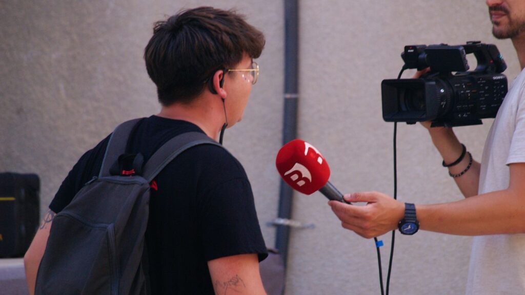 A person being interviewed with a microphone and camera