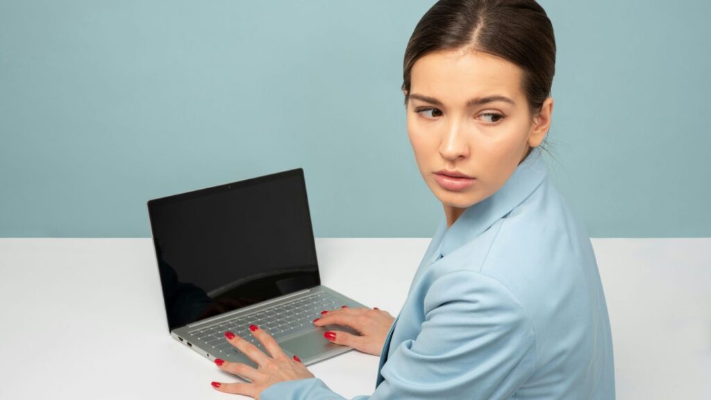 woman using laptop and looking side