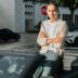 A man sitting on top of a car in a parking lot