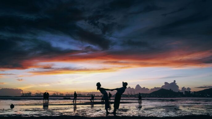 a group of people playing in the water at sunset