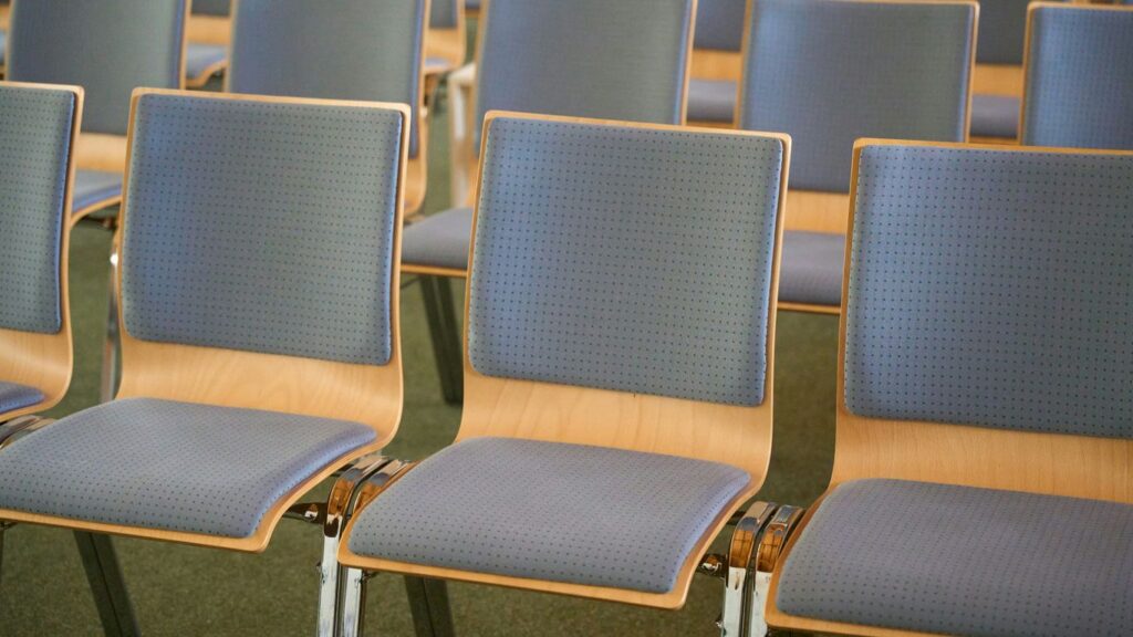 a row of blue chairs sitting in a room