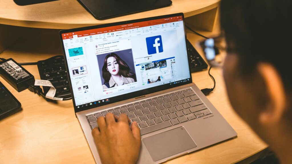person using laptop browsing facebook application