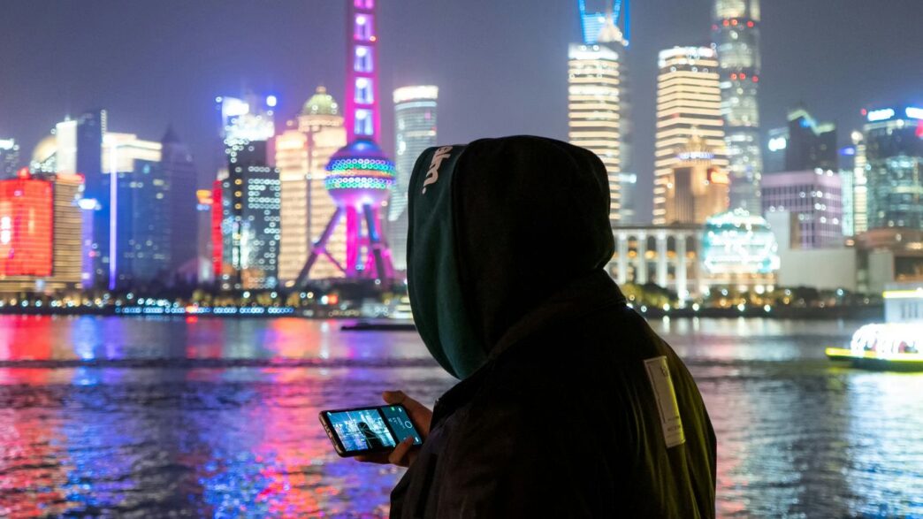 person in black hoodie standing near body of water during night time