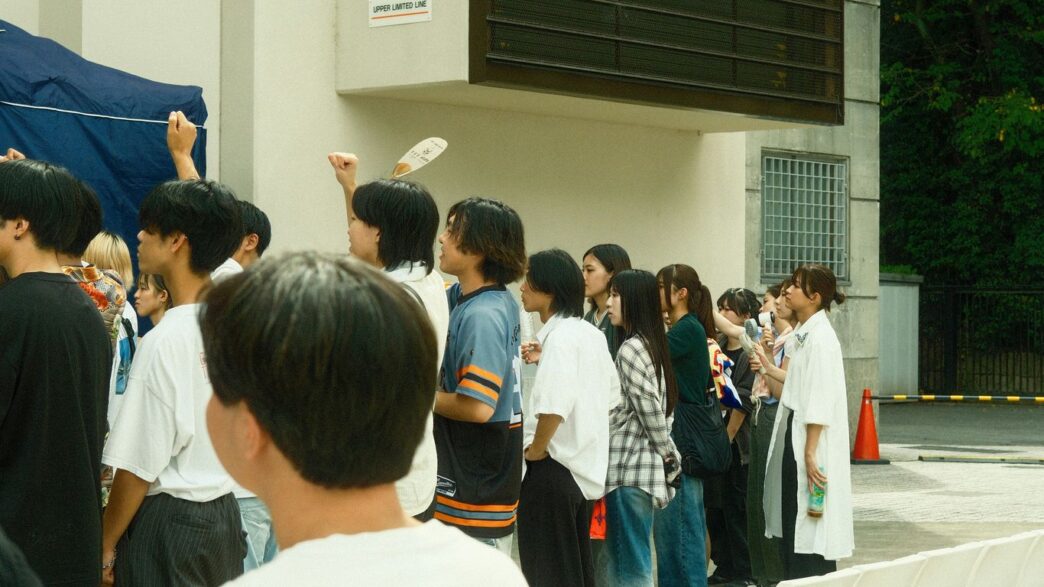 A diverse group of people standing in a line outdoors.