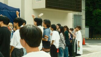 A diverse group of people standing in a line outdoors.