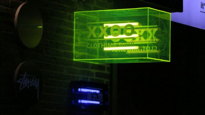 a neon sign hanging from the side of a brick building