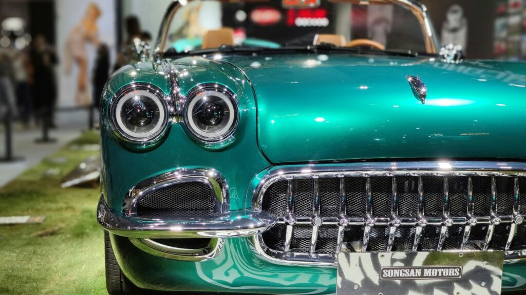 a green classic car on display at a car show