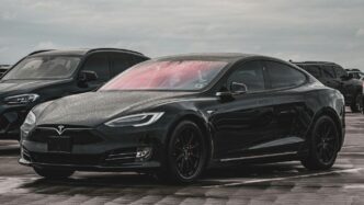 a black tesla parked in a parking lot