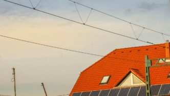 Orange roof with solar panels and overhead wires