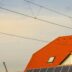 Orange roof with solar panels and overhead wires