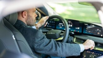 a man in a suit driving a car
