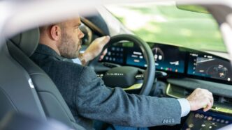 a man in a suit driving a car