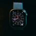 A smartwatch with a colorful face on a dark background