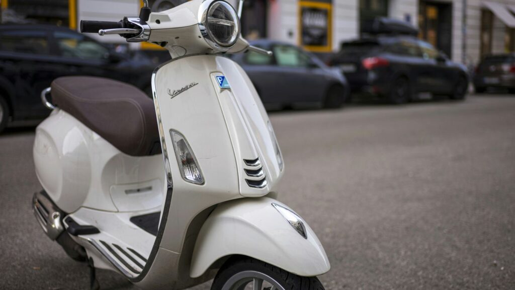 a white scooter parked on the side of the road