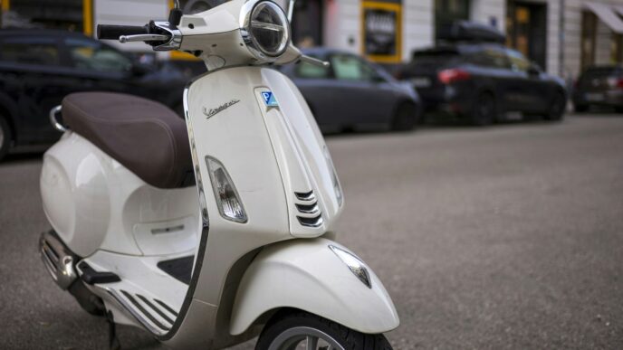 a white scooter parked on the side of the road