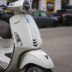 a white scooter parked on the side of the road