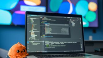 Laptop with code and a small plush octopus.