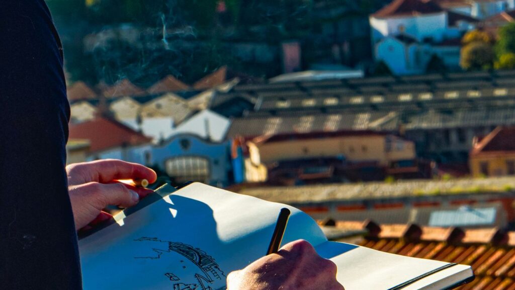 man sketching houses on roof
