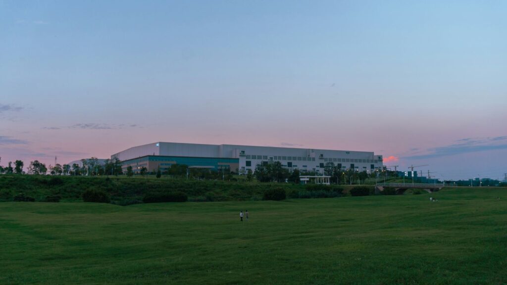 a large building sitting on top of a lush green field