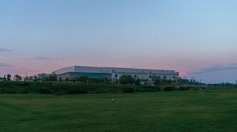 a large building sitting on top of a lush green field