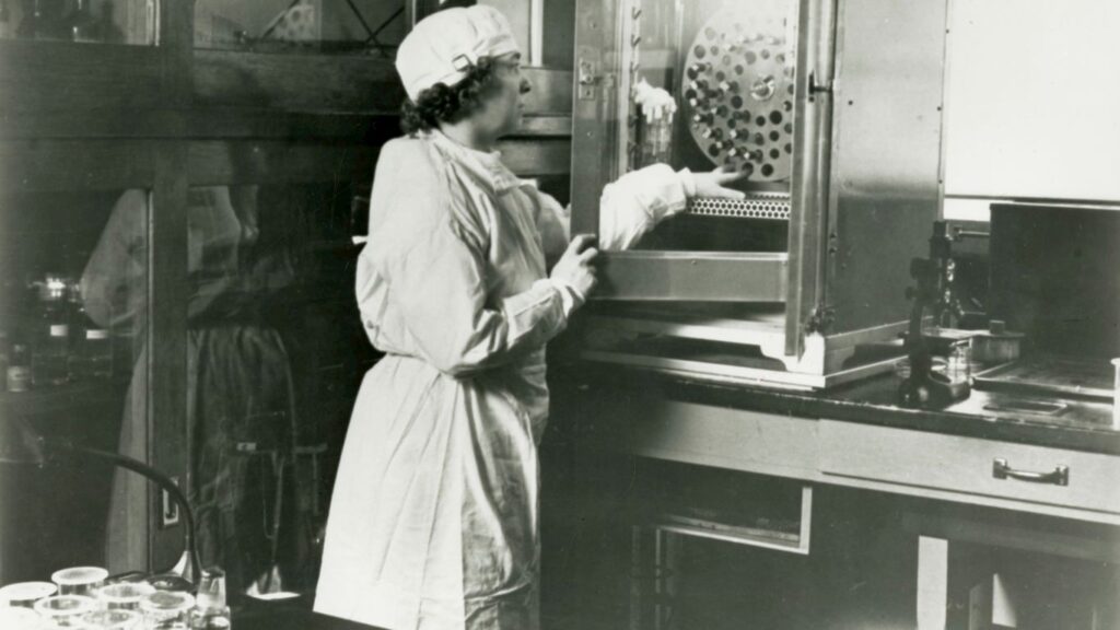 a black and white photo of a woman in a lab