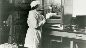 a black and white photo of a woman in a lab