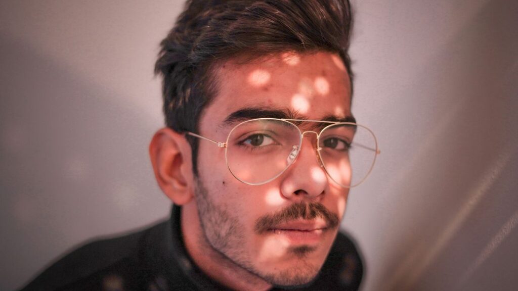 man in black crew neck shirt wearing silver framed eyeglasses